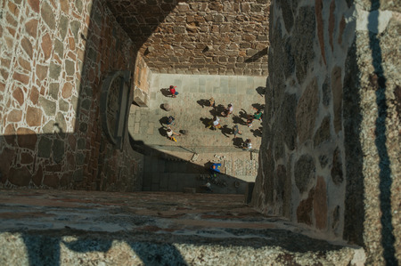 Avila, Spain - July 23, 2018. People seen by the bridge between two towers at the Alcazar Gate in Avila. It has the longest and imposing wall completely encircling this well-kept gothic town of Spain.のeditorial素材