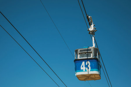 Cable car gondola passing through clear blue sky in a sunny day at the Teleferico Park of Madrid....