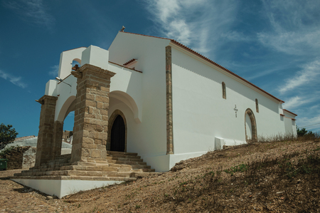 Unusual entrance church with two big stone columns and steps, in the cobblestone main street of Evoramonte. A tiny fortified civil parish over hill where stands out its historic castle in Portugal.の写真素材