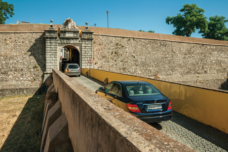 Elvas, Portugal - July 07, 2018. Street wit cars entering the city wall gateway on a sunny day at Elvas. A gracious star-shaped fortress city on the easternmost frontier of Portugal.のeditorial素材