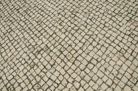 Close-up of white stone pavement in square shape on a sunny day, forming a singular background at...