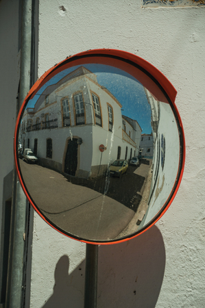 Old building on empty alley corner reflected in street mirror, in a sunny day at Campo Maior. A cute little town with Roman, Moorish and medieval influences in eastern Portugal.の写真素材