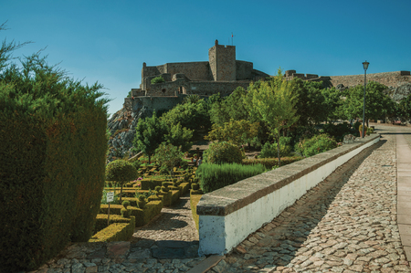 Marvao, Portugal - July 8, 2018. Walls and stone tower of the city Castle over hill with lush garden in Marvao. An amazing medieval fortified village perched on a granite crag in eastern Portugalのeditorial素材