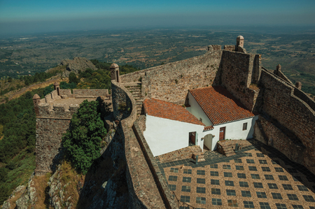 House and courtyard encircled by thick stone wall and countryside landscape, in a sunny day at the Marvao Castle. An amazing medieval fortified village perched on a granite crag in eastern Portugal.のeditorial素材