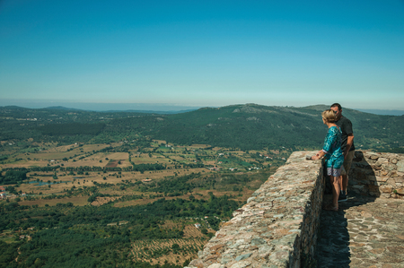 Marvao, Portugal - July 09, 2018. Couple of tourists looking at the hilly landscape from tower at the Marvao Castle. An amazing medieval fortified village perched on a crag in eastern Portugal.のeditorial素材