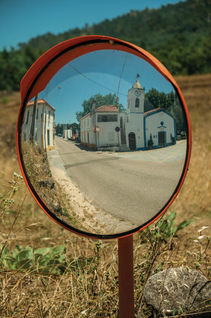 Little church and white house reflected in street mirror, in a sunny day in the small countryside village of Portagem. A district of MarvÃ£o at the bottom of a lush wooded valley in eastern Portugal.の写真素材