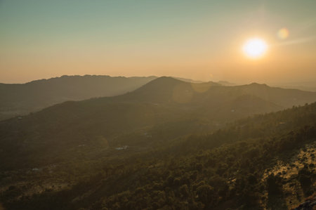 Mountainous landscape covered by trees, rocky hills and cultivated fields on sunset glow at Marvao....
