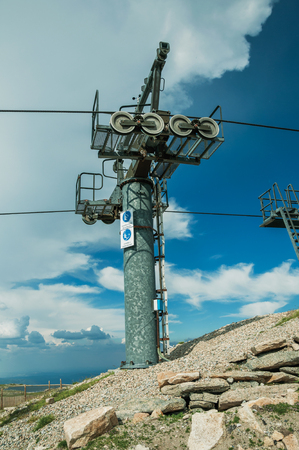 Chairlift towers and cables over hilly landscape covered by bushes and rocks, on the highlands at the Serra da Estrela. The highest mountain range in continental Portugal, with astonishing scenery.の写真素材