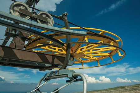 Close-up of the return bullwheel on upper terminal of chairlift, on sunny day at the Serra da...