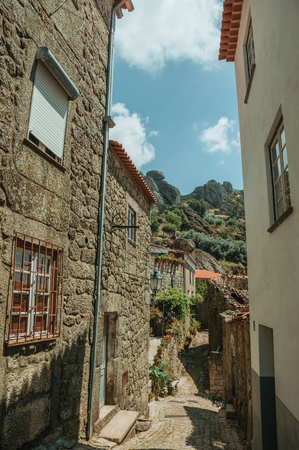 Narrow deserted alley on slope with charming old stone houses, on a sunny day at Monsanto. Considered one of the cutest and most peculiar historic village of Portugal.の写真素材