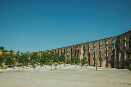 Amoreira Aqueduct with arches and rectangular pillars in front of wooden square at the western entrance of Elvas. A gracious star-shaped fortress city on the easternmost frontier of Portugal.の写真素材
