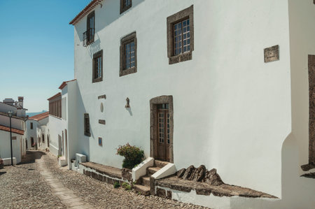 Marvao, Portugal - July 10, 2018. Facade of old house with whitewashed wall in cobblestone alley on slope at Marvao. An amazing medieval fortified village perched on a granite crag in eastern Portugalの写真素材