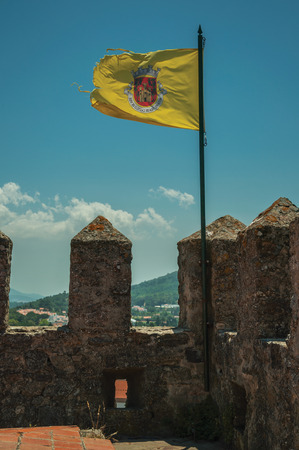 Flag with the coat of arms of the city fluttering in the wind on the castle wall at Castelo de Vide. Nice little town with medieval castle to ensure the defense of the Portugal eastern border.のeditorial素材