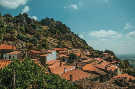 Rooftops of old stone houses with castle on top of rocky hill and countryside landscape, in a sunny day at Monsanto. Considered one of the cutest and most peculiar historic village of Portugal.の写真素材