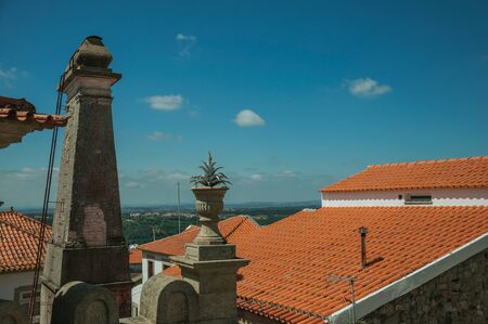 Roofs of houses and chimney with countryside landscape, in a sunny day at Seia. On foothill mountains, this friendly town in eastern Portugal is also known for its delicious artisanal cheese.の写真素材