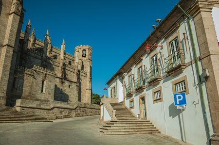 Old building with PARKING signpost and stone wall with pinnacles decoration on side of gothic Guarda Cathedral. This friendly and well-kept medieval town is the highest in the continental Portugal.の写真素材