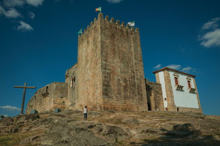 Belmonte, Portugal, July 18, 2018. Child running on rocky hill in front of wooden cross at the Belmonte Castle. A cute small town, birthplace of the navigator Pedro Alvares Cabral, on eastern Portugalのeditorial素材