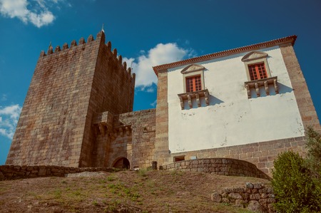 Stone walls and square tower over rocky hill, at the front facade of medieval Belmonte Castle. A cute small town, birthplace of the navigator Pedro Alvares Cabral, on eastern Portugal. Vintage filter.のeditorial素材