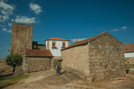 Belmonte, Portugal - July 18, 2018. Old woman next to gothic chapels at the Belmonte Castle. A cute small town, birthplace of the navigator Pedro Alvares Cabral, on eastern Portugal.のeditorial素材