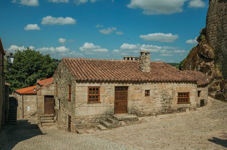 Gothic house with wooden door and staircase made of stone at deserted alley on slope, in a sunny day at Sortelha. One of the most astonishing and well preserved medieval villages in all Portugal.の写真素材