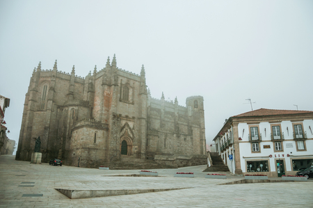 Guarda, Portugal - July 20, 2018. Gothic Cathedral facade with old buildings, in the morning mist of Guarda. This friendly and well-kept medieval town is the highest in the continental Portugal.のeditorial素材