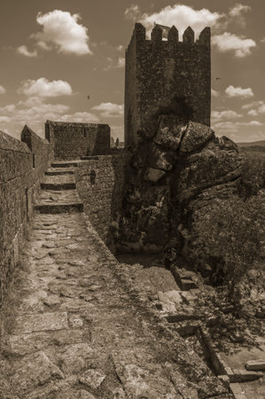 Pathway over thick stone wall with square tower from keep at the Sortelha Castle. One of the most astonishing and well preserved medieval villages in all Portugal. Black and white photo.のeditorial素材