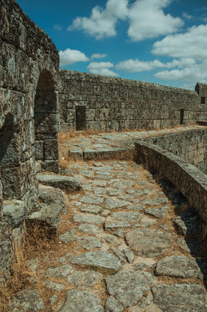 Close-up of pathway with dry grass on thick stone wall, in a sunny day at the Sortelha Castle. One of the most astonishing and well preserved medieval villages in all Portugal.のeditorial素材