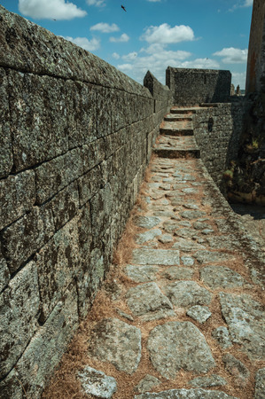 Pathway with dry grass on thick stone wall, in a sunny day at the Sortelha Castle. One of the most astonishing and well preserved medieval villages in all Portugal.のeditorial素材