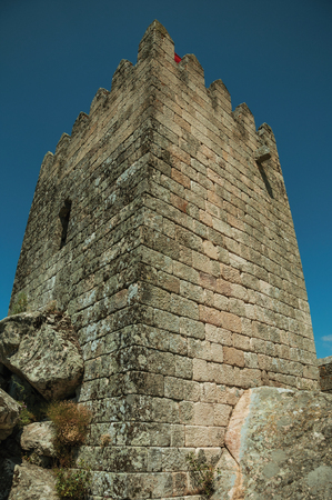 Square tower from keep made of stone over rocky terrain on top of hill, in a sunny day at the Sortelha Castle. One of the most astonishing and well preserved medieval villages in all Portugal.のeditorial素材