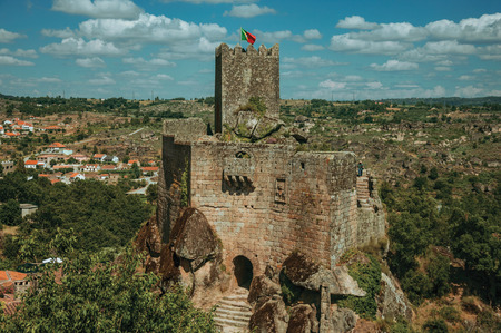 Stone Castle with square tower over rocky cliff and hilly landscape with roof houses, in a sunny day at Sortelha. One of the most astonishing and well preserved medieval villages in all Portugal.のeditorial素材