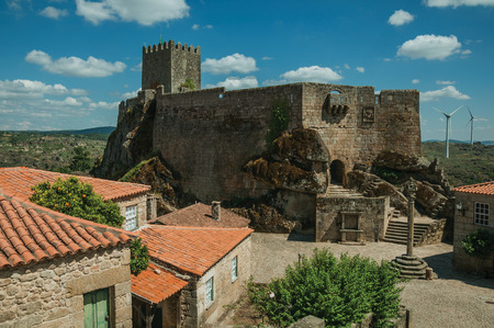 Stone Castle with tower over rocky hill and old houses encircling square with pillory, in a sunny day at Sortelha. One of the most astonishing and well preserved medieval villages in all Portugal.のeditorial素材