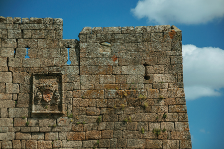 Family coat of arms carved on a wall made of stone bricks and blue sky, in a sunny day at the medieval Sortelha Castle. One of the most astonishing and well preserved medieval villages in all Portugalのeditorial素材