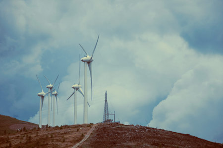 Large propeller blades from wind generators of electric power on hill, in cloudy day at Serra da...