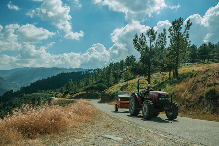 Serra da Estrela, Portugal - July 14, 2018. Tractor passing through road on hilly landscape at the Serra da Estrela ridge. The highest mountain range in continental Portugal, with astonishing scenery.のeditorial素材