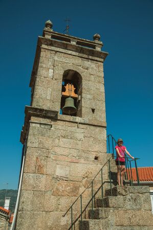 Belmonte, Portugal - July 16, 2018. Medieval bell tower and staircase with cute little girl in Belmonte. A cute small town, birthplace of the navigator Pedro Alvares Cabral, on eastern Portugal.の写真素材
