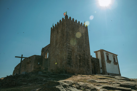 Stone walls and square tower over rocky hill with sunlight at the medieval Belmonte Castle. A small town, birthplace of the navigator Pedro Alvares Cabral, on eastern Portugal.のeditorial素材