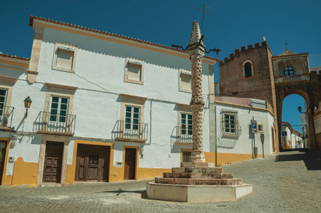 Deserted square of Santa Clara with marble pillory in the Manueline style and old buildings, on...