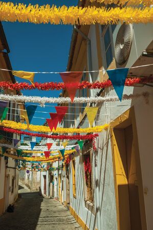 Deserted alley with festive colorful decoration and old terraced houses, on sunny day at Portalegre. A nice little town at the bottom of Mamede Mountain Range in eastern Portugal.の写真素材