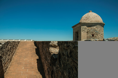 Pathway on top of thick stone wall with tower and merlons in sunny day at the Castle of Elvas. A gracious star-shaped fortress city on the easternmost frontier of Portugal.のeditorial素材