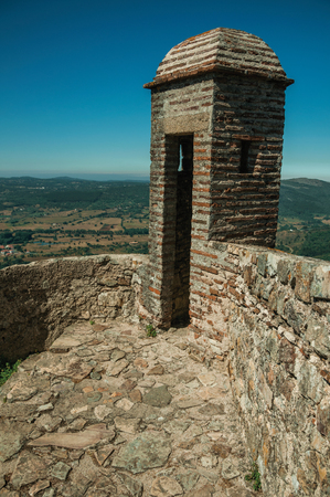 Marvao, Portugal - July 9, 2018. Man standing along pathway on top of thick stone wall, in a sunny day at the Castle. An amazing medieval fortified village perched on a crag in eastern Portugalのeditorial素材
