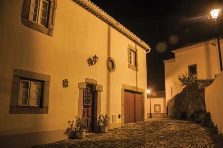 Charming facade of old corner house in between two cobblestone alleys on slope, at dusk in Marvao. An amazing medieval fortified village perched on a granite crag in eastern Portugal.のeditorial素材
