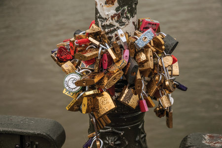 Paris, northern France - July 10, 2017. Padlocks fastened to each other celebrating love on pole over bridge at the Seine River in Paris. Known as one of the most impressive worldâs cultural center.のeditorial素材