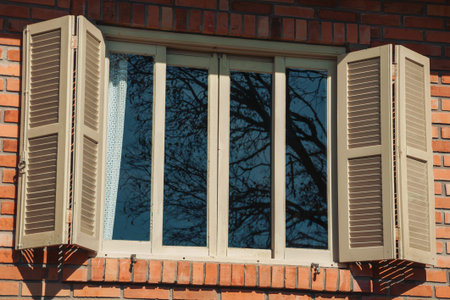 Glazed window with open shutters in a country house with brick wall, on a farm near Bento Goncalves....