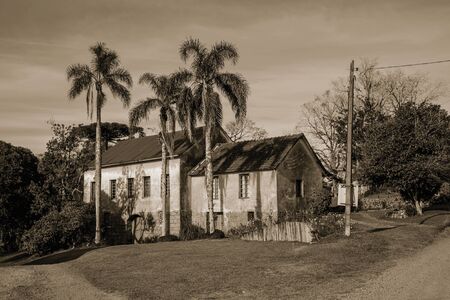 Charming countrified house in typical Italian-influenced style and dirt road near Bento Goncalves. A friendly country town in southern Brazil famous for its wine production. Black and white photo.の写真素材