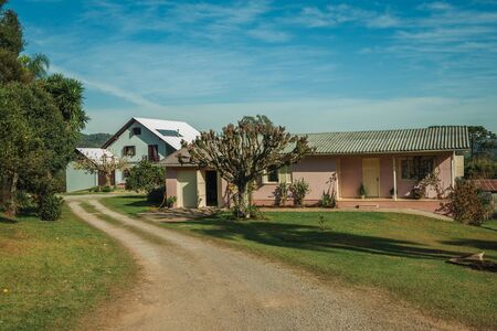Charming modern country house with pathway and a lush garden, in a rural landscape near Bento Goncalves. A friendly country town in southern Brazil famous for its wine production.の写真素材