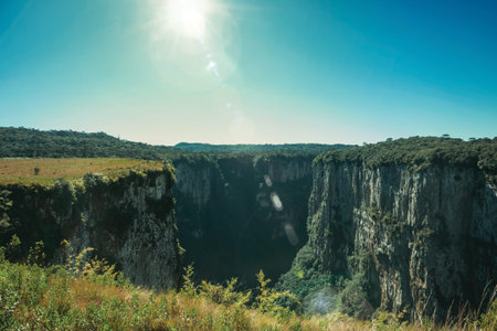 Itaimbezinho Canyon with steep rocky cliffs on a flat plateau and sunlight near Cambara do Sul. A small country town in southern Brazil with amazing natural tourist attractions. Retouched photo.の写真素材