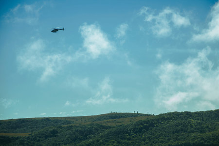 Helicopter flying over the Fortaleza Canyon with cliffs covered by thick forest in a cloudy day near Cambara do Sul. A small country town in southern Brazil with amazing natural tourist attractions.の写真素材