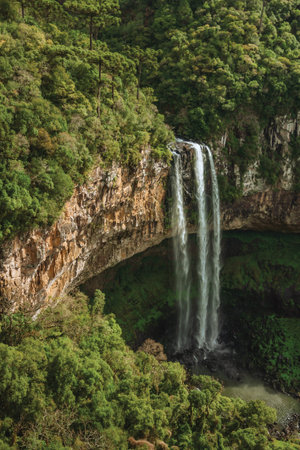 Caracol waterfall falling from rocky cliff forming a cave facing a canyon covered by forest in a park near Canela. A charming small town very popular by its ecotourism in southern Brazil.の写真素材