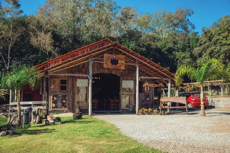 Bento Goncalves, Brazil - July 11, 2019. Wooden facade of rustic restaurant and trees in a farm near Bento Goncalves. A friendly country town in southern Brazil famous for its wine production.のeditorial素材