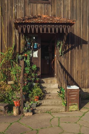 Bento Goncalves, Brazil - July 11, 2019. Decorated entrance with plants and stairs on the facade of charming wooden house near Bento Goncalves. A friendly country town famous for its wine production.のeditorial素材